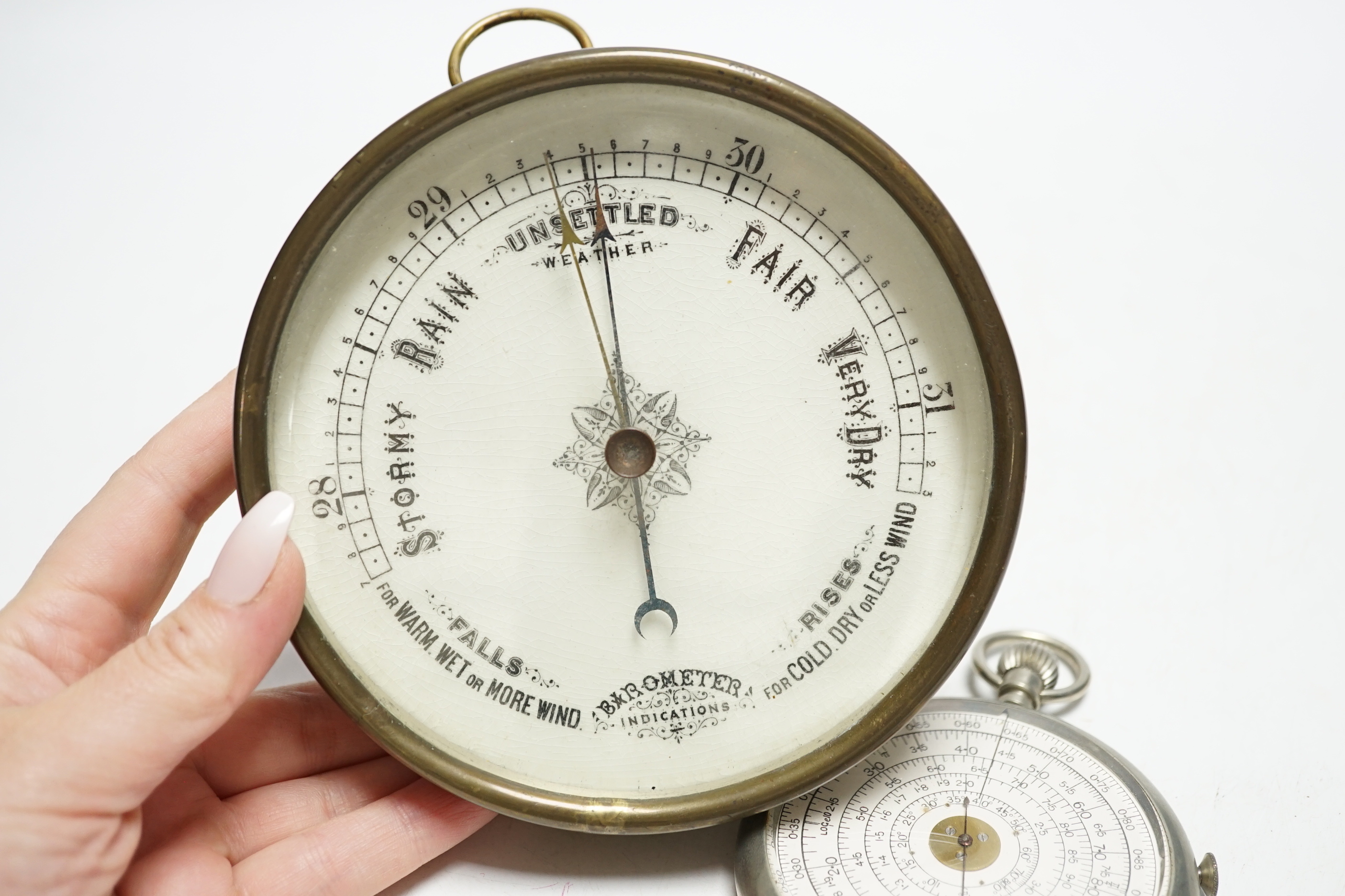 An aneroid barometer and a pocket calculator, calculator 11cm high